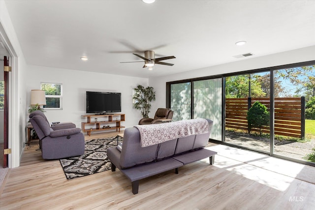 living area with light wood-type flooring, visible vents, recessed lighting, and a ceiling fan