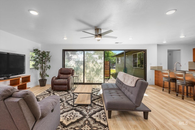 living room with recessed lighting, light wood-style flooring, baseboards, and visible vents