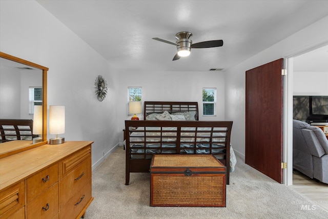 bedroom with multiple windows, baseboards, and light carpet