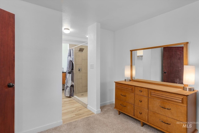 bedroom with baseboards and light colored carpet