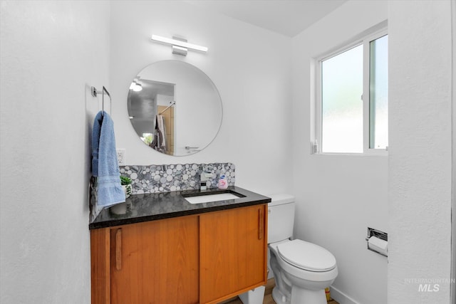 bathroom with vanity, curtained shower, toilet, and backsplash