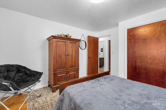 bedroom with a textured ceiling and baseboards