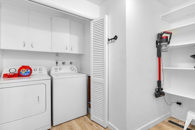 laundry room featuring visible vents, baseboards, light wood finished floors, cabinet space, and washer and dryer