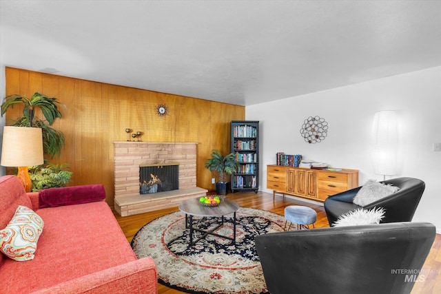 living area featuring wooden walls, wood finished floors, and a fireplace