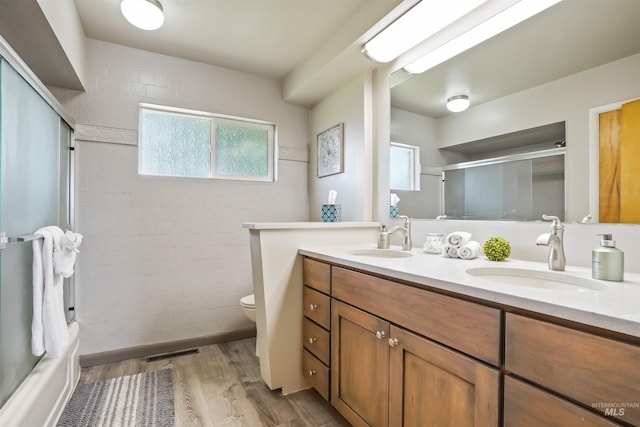 full bathroom featuring shower / bathing tub combination, hardwood / wood-style floors, vanity, and toilet