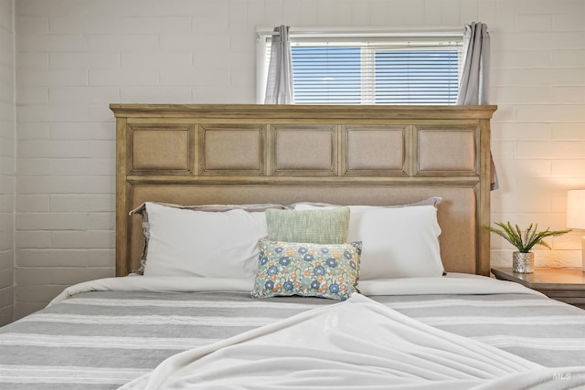 bedroom featuring brick wall