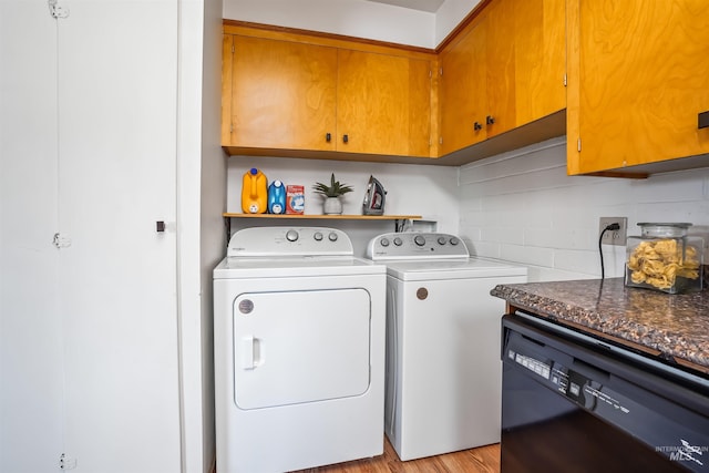 clothes washing area with light hardwood / wood-style floors, cabinets, and separate washer and dryer