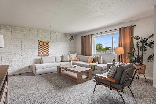 living room featuring carpet, a textured ceiling, and brick wall