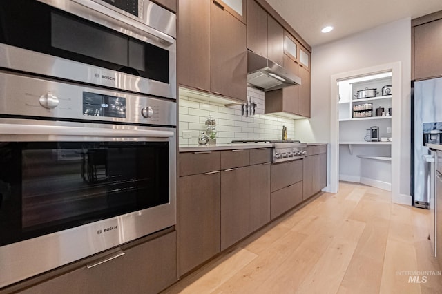 kitchen featuring backsplash, stainless steel appliances, and light hardwood / wood-style floors