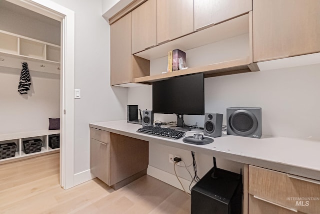 office featuring light wood-type flooring and built in desk