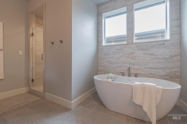 bathroom with separate shower and tub and tile patterned flooring