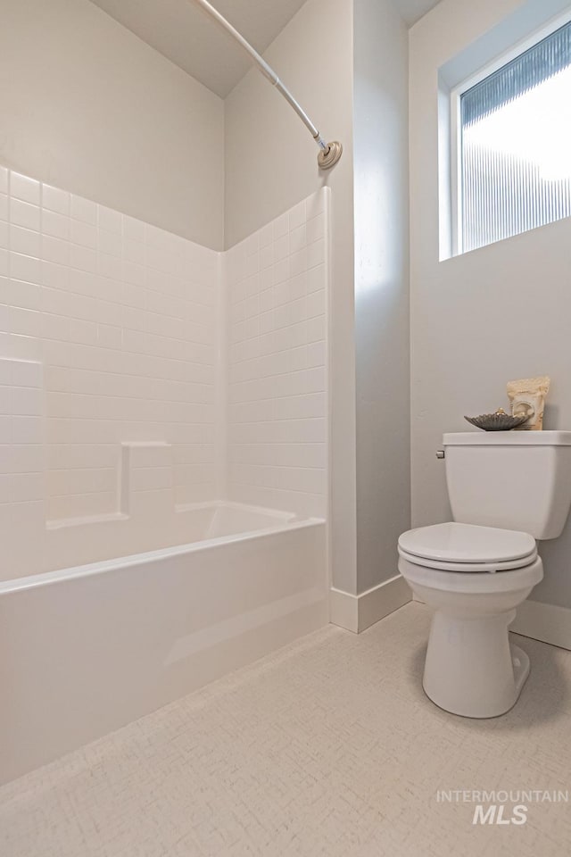 bathroom featuring washtub / shower combination and toilet