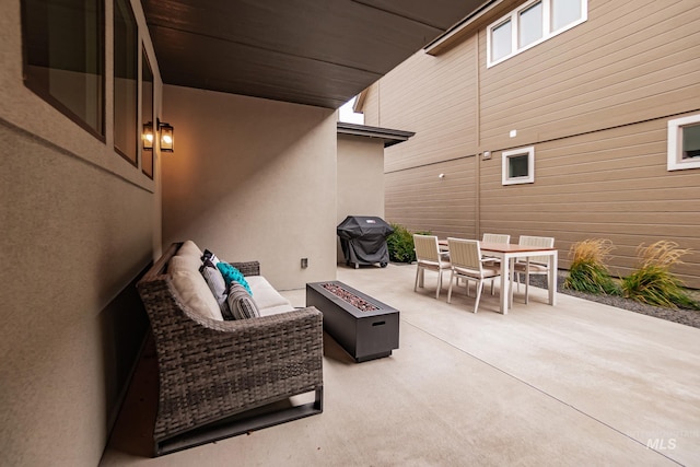 view of patio with area for grilling and an outdoor living space with a fire pit