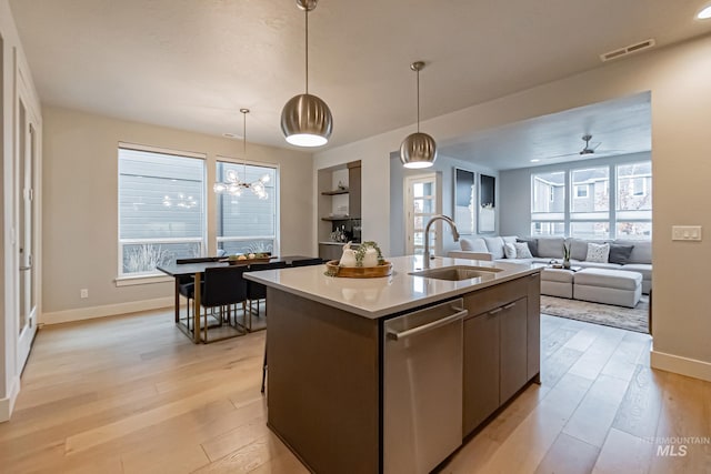 kitchen featuring plenty of natural light, an island with sink, stainless steel dishwasher, and light hardwood / wood-style floors