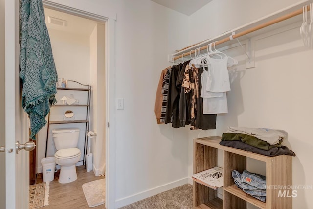 walk in closet featuring visible vents and wood finished floors