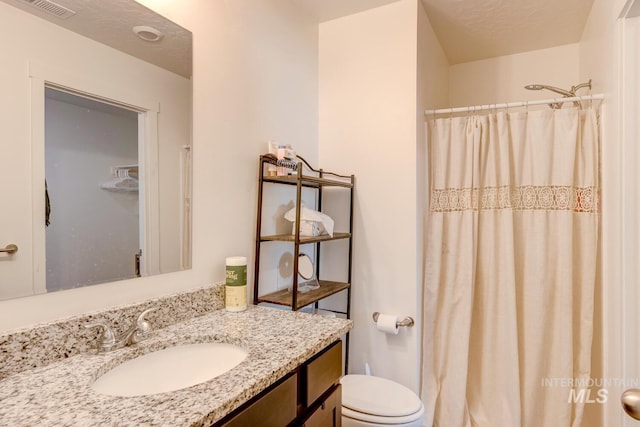 bathroom with visible vents, toilet, vanity, and a shower with curtain