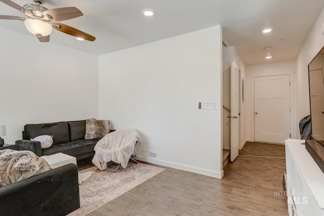 living area with recessed lighting, light wood-style floors, and baseboards