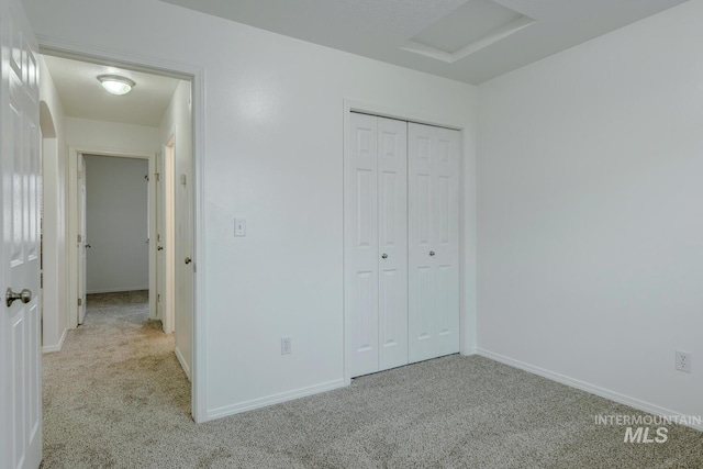 unfurnished bedroom with light colored carpet and a closet