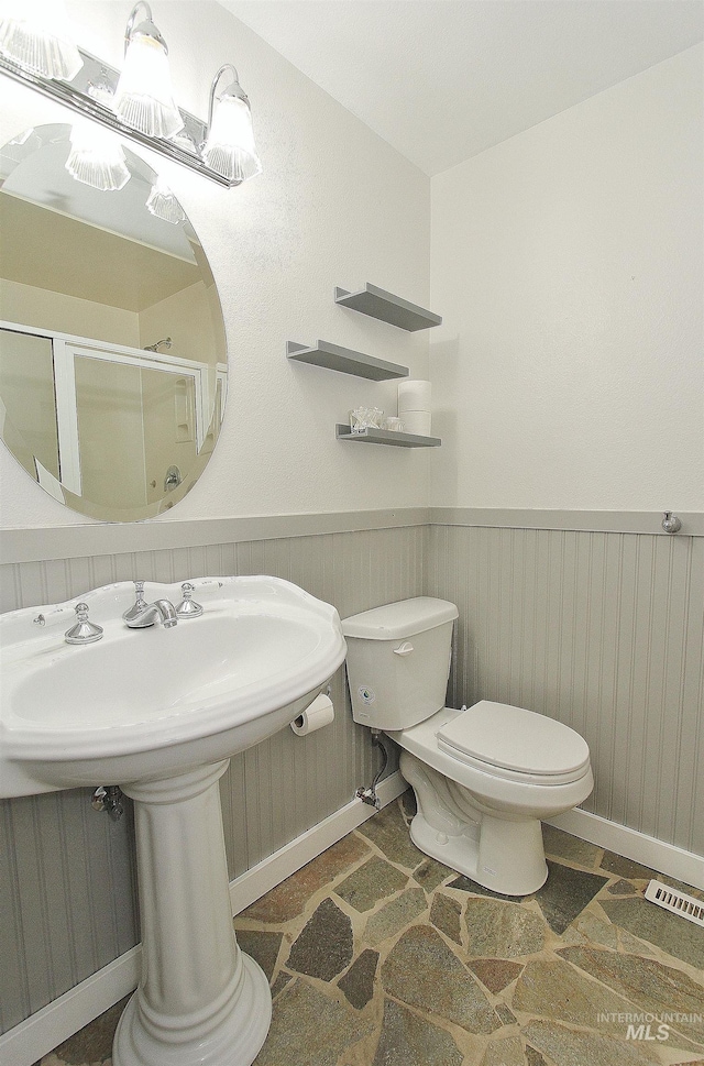 2155 N 24th St, Boise, ID 83702 - bathroom with toilet, a wainscoted wall, a stall shower, and baseboards