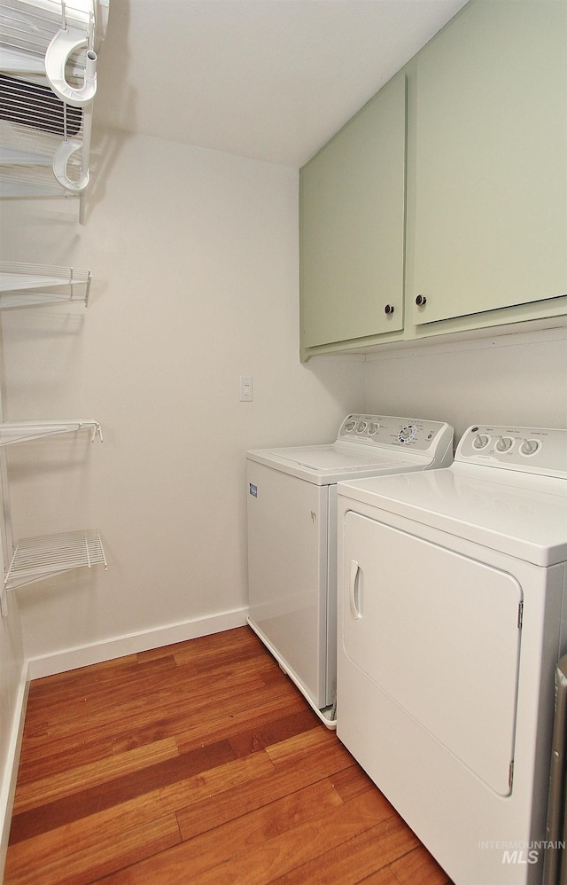 2155 N 24th St, Boise, ID 83702 - washroom featuring cabinet space, independent washer and dryer, light wood-style floors, and baseboards