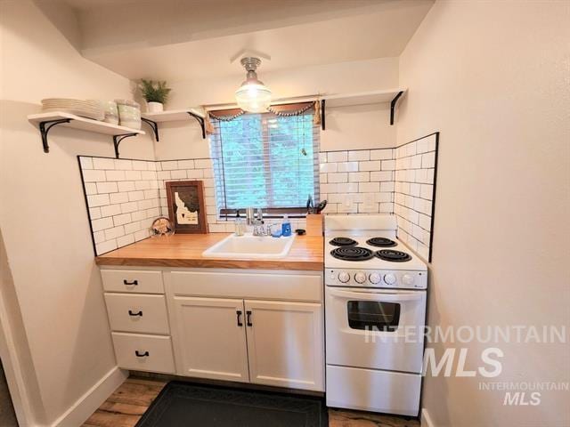 kitchen with sink, wooden counters, white cabinetry, electric range, and tasteful backsplash