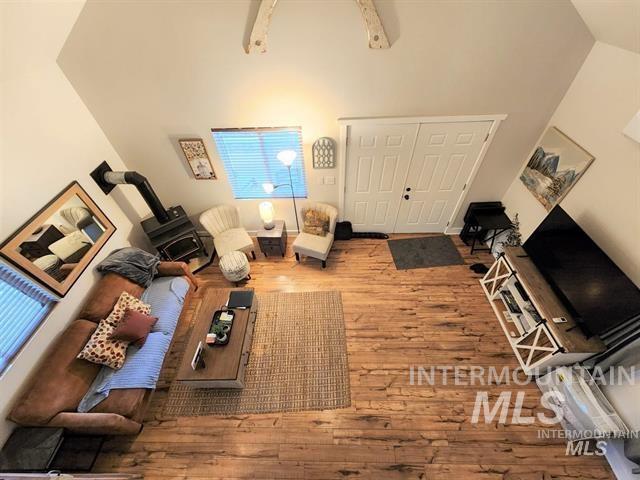 living room featuring wood-type flooring and high vaulted ceiling