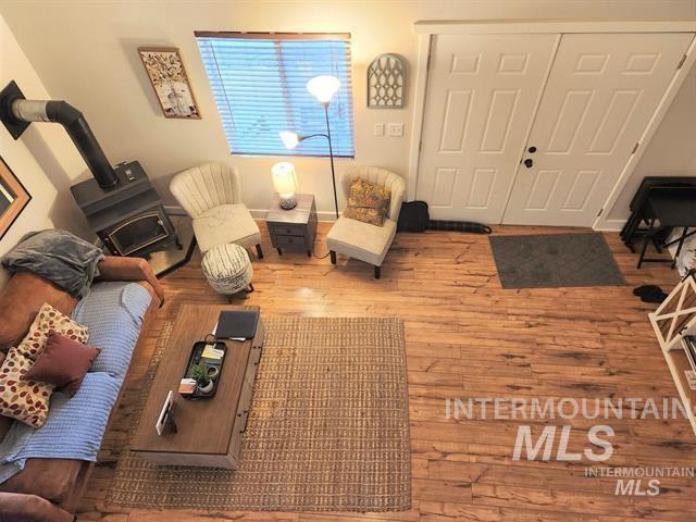 living room featuring wood-type flooring and a wood stove