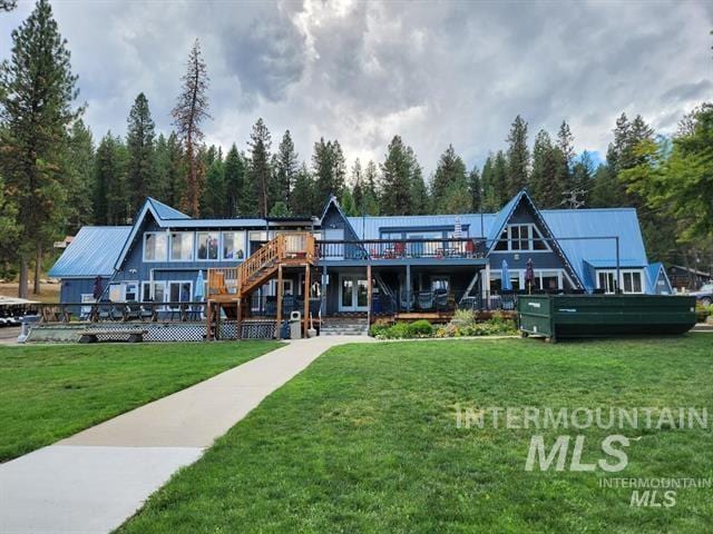 rear view of property with a wooden deck and a yard