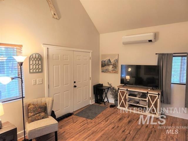 living room with hardwood / wood-style flooring, vaulted ceiling, and a wall mounted air conditioner