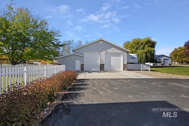 view of front facade with a front yard, an outbuilding, and a garage