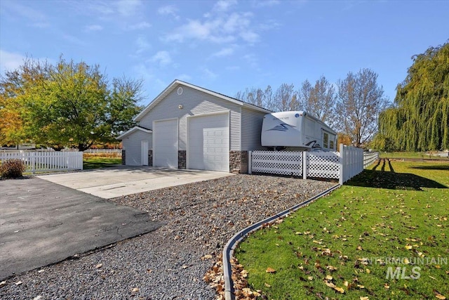 rear view of property with a lawn, an outbuilding, and a garage