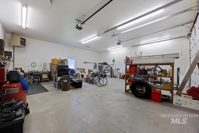 garage featuring a garage door opener and a workshop area