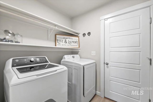 washroom featuring laundry area, independent washer and dryer, and light wood-style flooring