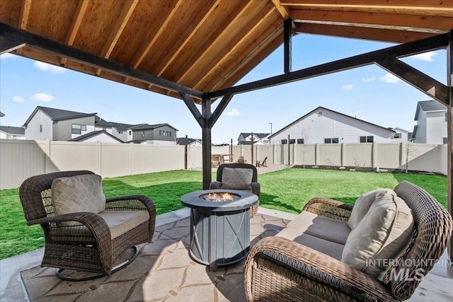 view of patio / terrace with a fenced backyard, a residential view, and an outdoor living space with a fire pit