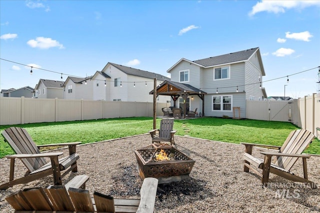 back of property with a patio, a fire pit, a gazebo, a yard, and a gate