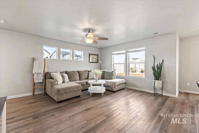 living room with a ceiling fan, baseboards, visible vents, and wood finished floors