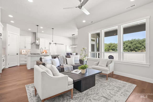 living area with visible vents, recessed lighting, ceiling fan, and wood finished floors