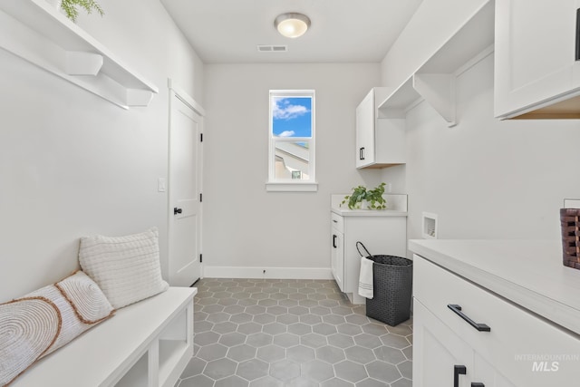 washroom featuring visible vents, cabinet space, baseboards, and washer hookup