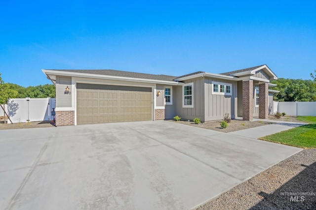 view of front of house featuring a gate, an attached garage, fence, and board and batten siding