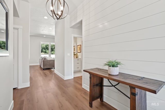 entryway with an inviting chandelier, recessed lighting, wood finished floors, and baseboards