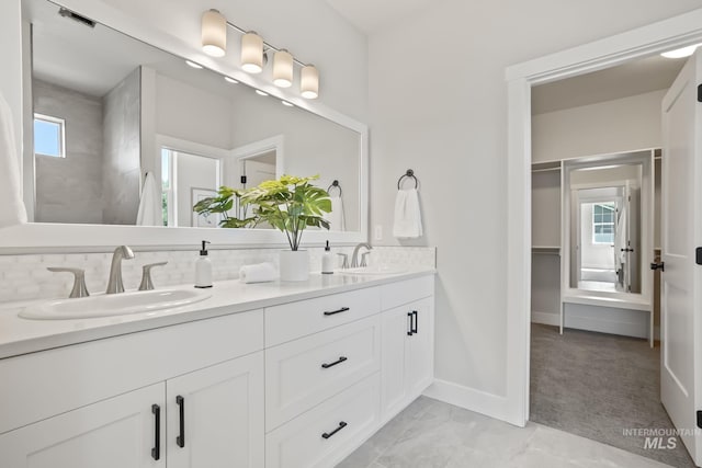 bathroom with double vanity, visible vents, backsplash, and a sink