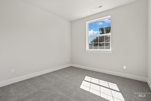 empty room featuring visible vents, carpet flooring, and baseboards