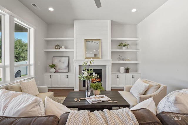 living room featuring a large fireplace, recessed lighting, dark wood-type flooring, and a ceiling fan