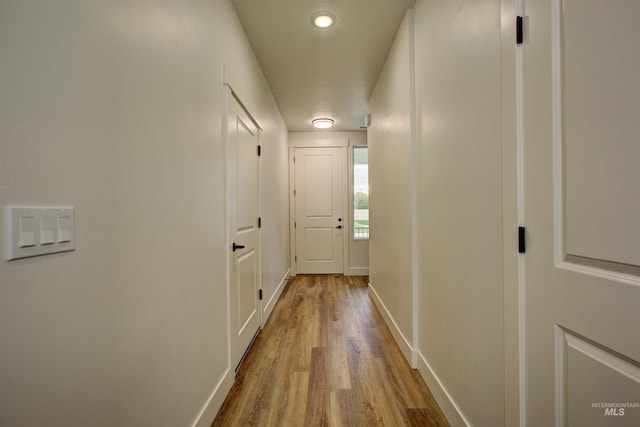 hallway with baseboards and wood finished floors