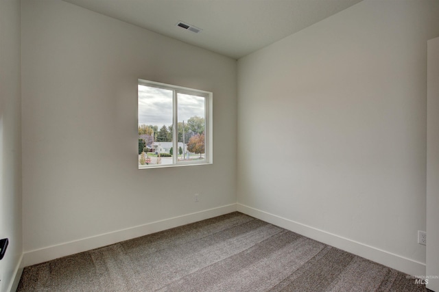 carpeted spare room featuring baseboards and visible vents