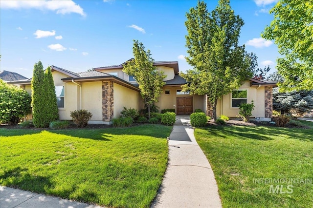 view of front of home featuring stone siding, stucco siding, and a front lawn