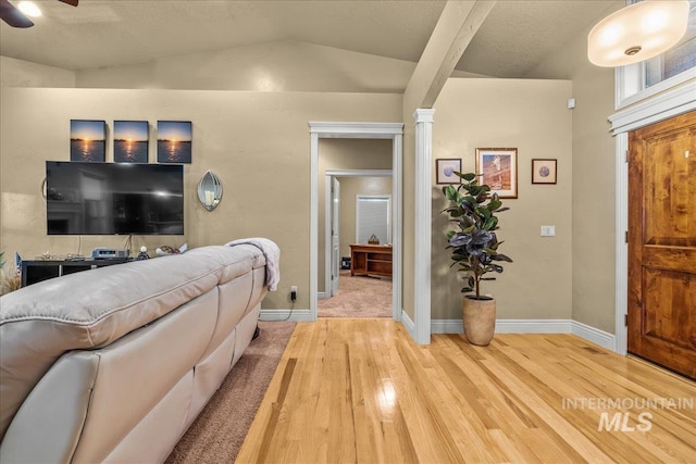 entryway featuring vaulted ceiling, baseboards, light wood-type flooring, and a ceiling fan