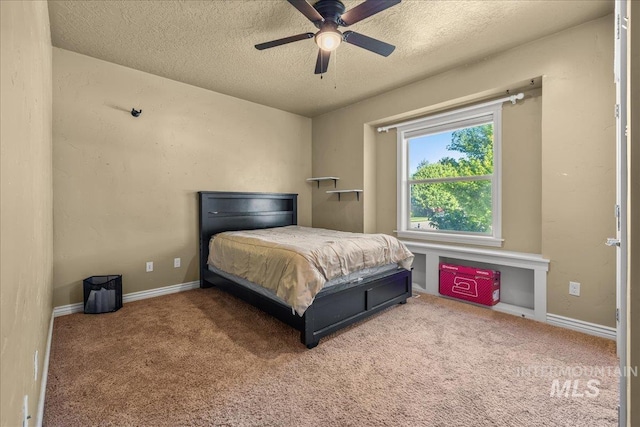 bedroom featuring a textured ceiling, carpet floors, baseboards, and a ceiling fan