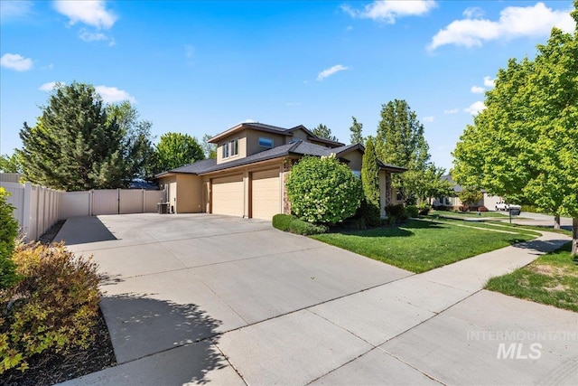 view of front of property with a garage, stucco siding, fence, concrete driveway, and a front lawn