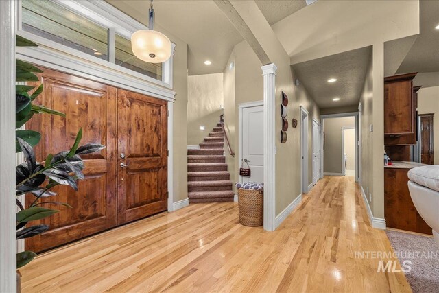 foyer entrance featuring stairway, light wood-style flooring, baseboards, and recessed lighting